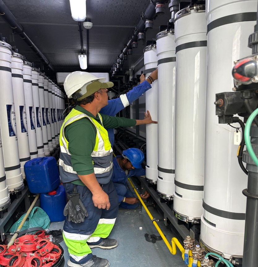 Technicians servicing an array of water filtration membrane vessels