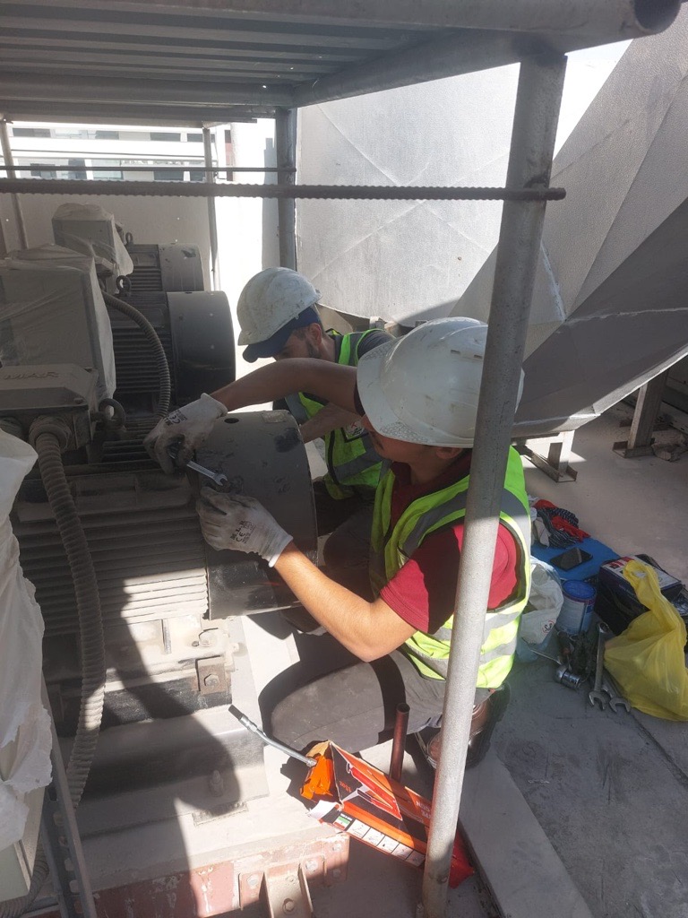 Two technicians performing planned maintenance on rooftop equipment