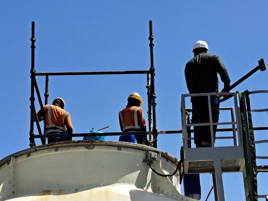Crew on scaffolding servicing a water tank